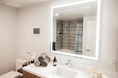 a white bathroom with a sink and a mirror at Elegant Apartment in the Heart of Hollywood in Los Angeles