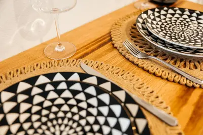a wooden table with plates and a wine glass at Elegant Apartment in the Heart of Hollywood in Los Angeles