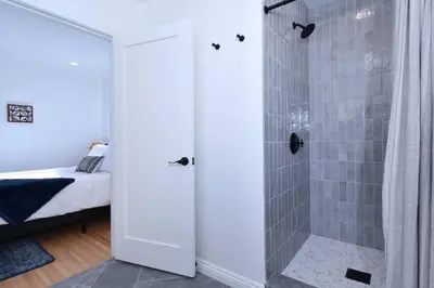 a bathroom with a walk in shower next to a bed at Beautiful 3 Bed Home with a Large Back Yard Outdoor Space in Los Angeles