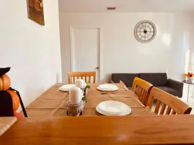 a wooden table with white plates on top of it at Charming 3BR Retreat near Disneyland Downtown LA! in Rowland Heights