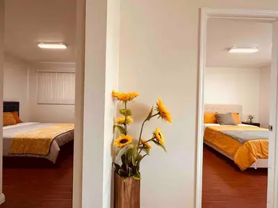 a bedroom with two beds and a vase with sunflowers at Charming 3BR Retreat near Disneyland Downtown LA! in Rowland Heights