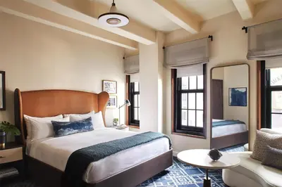 a bedroom with a bed and a living room at Hotel Figueroa, Unbound Collection by Hyatt in Los Angeles