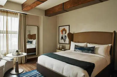 a bedroom with a large bed and a mirror at Hotel Figueroa, Unbound Collection by Hyatt in Los Angeles