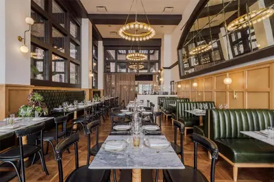 a dining room with tables and green leather chairs at Hotel Figueroa, Unbound Collection by Hyatt in Los Angeles