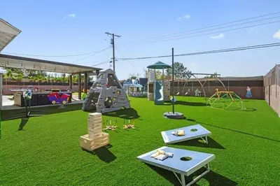 a park with a playground with a slide and swings at The Disneyland Dream by OC Adventure Homes in Garden Grove