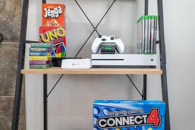 a shelf with a video game controller and a box at Underwater Voyage by OC Adventure Homes in Garden Grove
