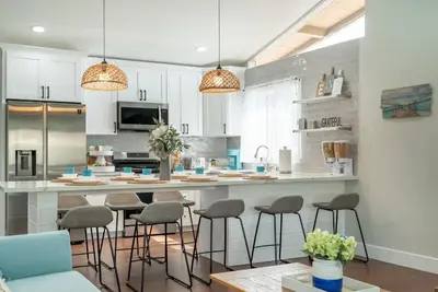 a kitchen with a large counter with stools in it at Underwater Voyage by OC Adventure Homes in Garden Grove