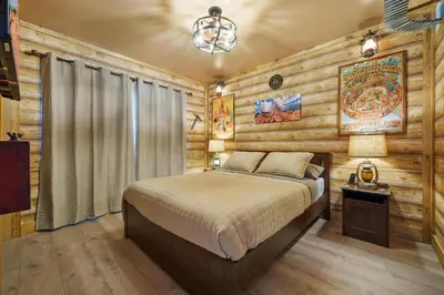 a bedroom with a bed in a room with wooden walls at The Disneyland Dream by OC Adventure Homes in Garden Grove