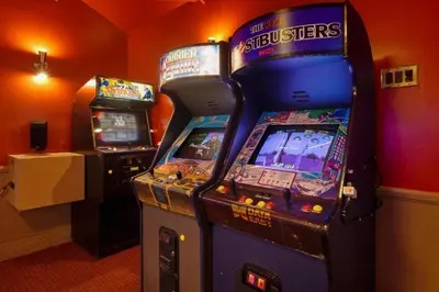 two video game machines sitting next to each other at The Disneyland Dream by OC Adventure Homes in Garden Grove