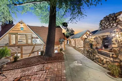 a house with a stone wall and a sidewalk at The Magic Castle (Unit5) - Six Flags in Newhall