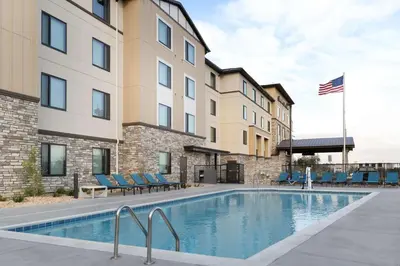 a pool in front of a building with chairs and a flag at Hampton Inn & Suites Porter Ranch Los Angeles in Deer Lake Highlands