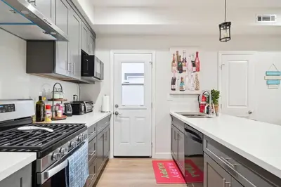 a kitchen with white counters and a stove top oven at Incredible Value for 12 guests, New 3BR Home by Disneyland, Knott's, Beach in Midway City