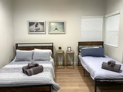 two beds in a bedroom with towels on them at Incredible Value for 12 guests, New 3BR Home by Disneyland, Knott's, Beach in Midway City