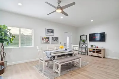 a dining room with a table and a ceiling fan at Incredible Value for 12 guests, New 3BR Home by Disneyland, Knott's, Beach in Midway City