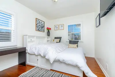 a bedroom with a white bed and a desk at Coastal Retreat With a minimum stay of 30 days in Lakewood