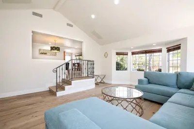 a living room with a blue couch and a table at Beautiful Spacious Home in Los Angeles