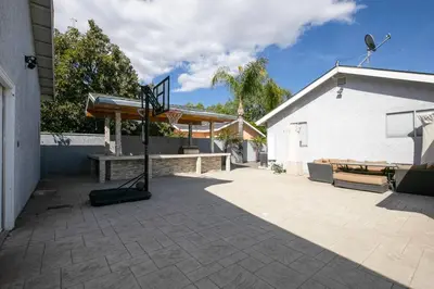 a basketball hoop and a bench in a courtyard at Beautiful Spacious Home in Los Angeles