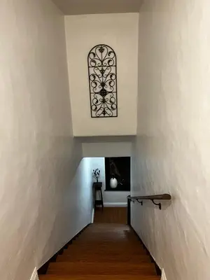 a stairway with a window in a white wall at Historic Spanish Home at Hollywood Beach in Oxnard