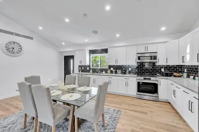 a kitchen with a table and chairs and a clock at LA Home near Universal Studios and Hollywood in Los Angeles