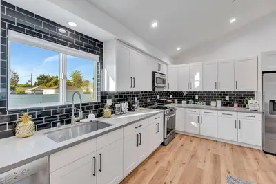 a kitchen with white cabinets and a large window at LA Home near Universal Studios and Hollywood in Los Angeles