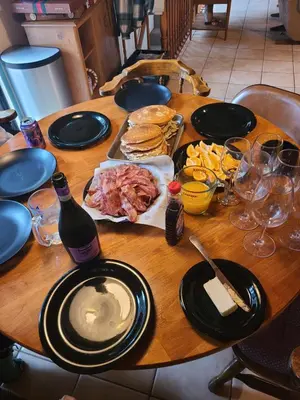 a table with plates of food and a bottle of wine at A-Frame Cabin in The Sequoias in Wofford Heights