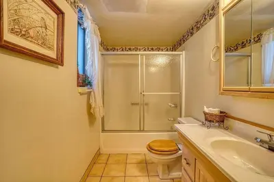 a bathroom with a shower and a toilet and a sink at A-Frame Cabin in The Sequoias in Wofford Heights