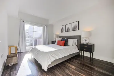 a white bedroom with a large bed and a window at Outstanding 2BDR in SM- 5-15 mins to the beach! in Los Angeles
