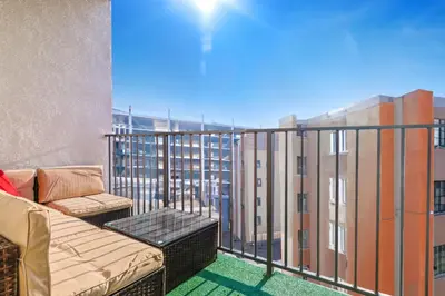 a balcony with a couch and chairs on a building at Outstanding 2BDR in SM- 5-15 mins to the beach! in Los Angeles