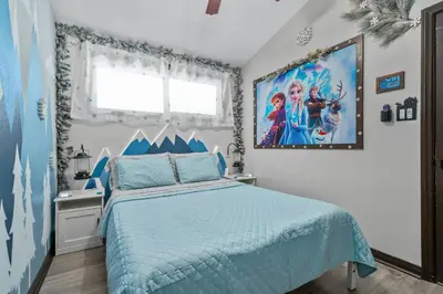 a bedroom with a blue bed and a large painting on the wall at Great Outdoors by OC Adventure Homes in Garden Grove