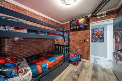 a bedroom with two bunk beds and a brick wall at Avengers Campus by OC Adventure Homes in Buena Park