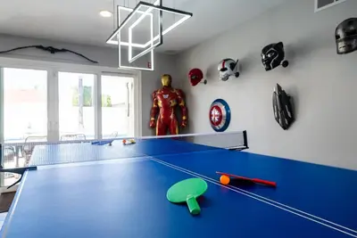 a ping pong table in a room with a superhero at Avengers Campus by OC Adventure Homes in Buena Park