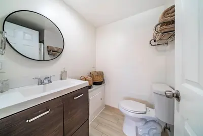 a bathroom with a white toilet and a mirror at Dino Disneyland by OC Adventure Homes in Garden Grove