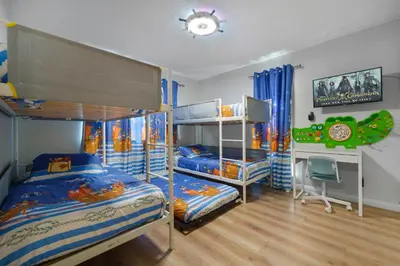 a bedroom with two bunk beds and a desk at Pirate Cove by OC Adventure Homes in Garden Grove