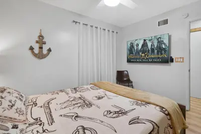 a bedroom with a bed with a poster on the wall at Pirate Cove by OC Adventure Homes in Garden Grove