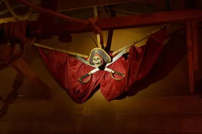 a mask is hanging on a clothes line with red cloth at Pirate Cove by OC Adventure Homes in Garden Grove