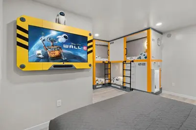 a room with a yellow room with a tv on a wall at Galaxy Quest by OC Adventure Homes in Garden Grove