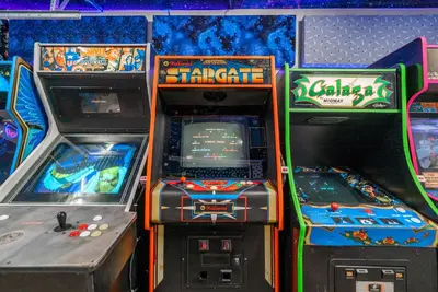 a group of arcade video games in a room at Galaxy Quest by OC Adventure Homes in Garden Grove