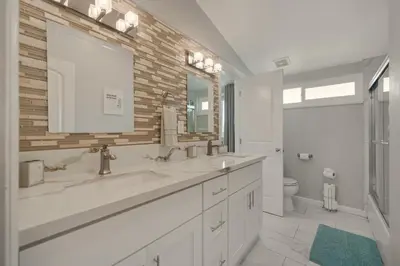 a bathroom with two sinks and a mirror and a toilet at Safari Adventure by OC Adventure Homes in Garden Grove