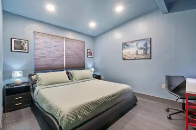 a bedroom with a bed and a desk and a chair at Galactic Dream by OC Adventure Homes in Garden Grove