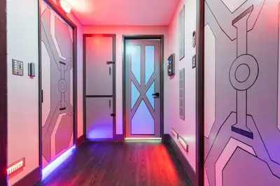 a hallway with a door with a painting on the wall at Galactic Dream by OC Adventure Homes in Garden Grove