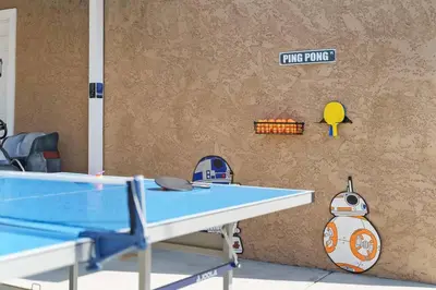 a ping pong table in front of a wall at Galactic Dream by OC Adventure Homes in Garden Grove