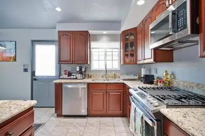 a kitchen with wooden cabinets and a stove top oven at Galactic Dream by OC Adventure Homes in Garden Grove