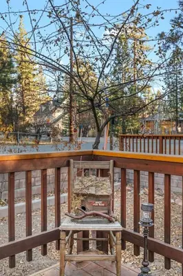 a wooden railing with a table on a porch at Green Pines Lake Retreat Walk to Lake in Big Bear Lake