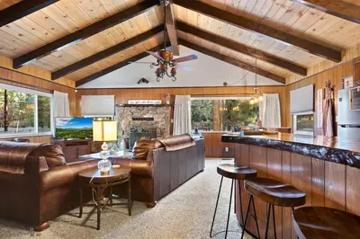 a living room with a bar and leather furniture at Green Pines Lake Retreat Walk to Lake in Big Bear Lake