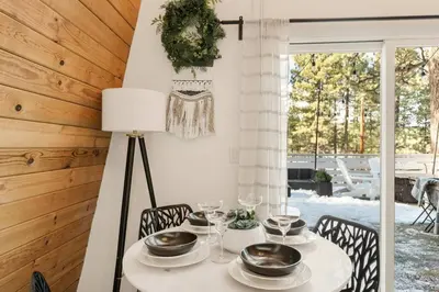 a dining room with a table with plates and glasses at Lucky Bear Cabin in Big Bear Lake