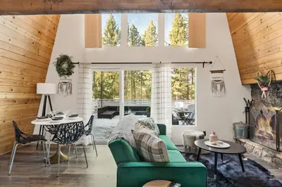 a living room with a green couch and a fireplace at Lucky Bear Cabin in Big Bear Lake