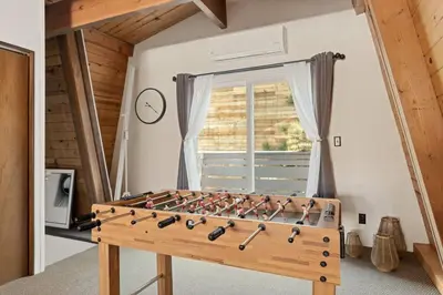 a foosball table in a room with a window at Lucky Bear Cabin in Big Bear Lake