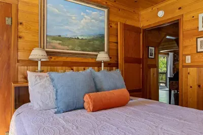 a bedroom with a bed with an orange pillow on it at Boulder Bay Getaway in Big Bear Lake