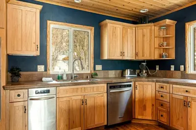 a kitchen with wooden cabinets and stainless steel appliances at Slope Vista Escape in Fawnskin