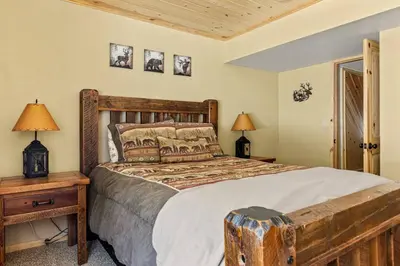 a bedroom with a large bed with a wooden headboard at Slope Vista Escape in Fawnskin